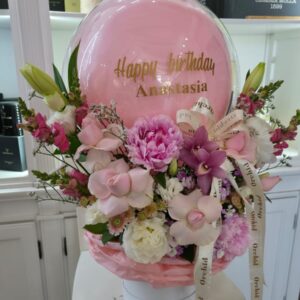 🎈 כדור פורח פרחים – מתנה ליום הולדת 🎈 מחפשים מתנה מהממת ומרגשת? סידור פרחים בצורת כדור פורח עם בלון אישי בטקסט לבחירה (לדוגמה: "Happy Birthday Anastasia") – משולב עם פרחים רכים בגווני ורוד, לבן וסגול. 💐 הסידור כולל: ורדים, סחלבים, ליזיאנטוס, פוני, לוע הארי ופרחי ליווי. 🎈 בלון שקוף עם כיתוב אישי בזהב, עטוף בבד ורוד רך. 🎁 מגיע בכלי לבן דקורטיבי עם סרט ממותג "Orchid". מושלם כמתנה ליום הולדת לנשים, לחברות, לאמא או לכל אדם אהוב. 📦 כולל משלוח לכל אזור הצפון – כרמיאל, נהריה, עכו, קריית ביאליק והסביבה.