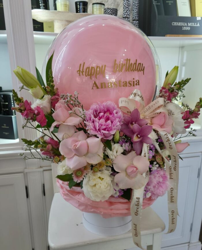 🎈 כדור פורח פרחים – מתנה ליום הולדת 🎈 מחפשים מתנה מהממת ומרגשת? סידור פרחים בצורת כדור פורח עם בלון אישי בטקסט לבחירה (לדוגמה: "Happy Birthday Anastasia") – משולב עם פרחים רכים בגווני ורוד, לבן וסגול. 💐 הסידור כולל: ורדים, סחלבים, ליזיאנטוס, פוני, לוע הארי ופרחי ליווי. 🎈 בלון שקוף עם כיתוב אישי בזהב, עטוף בבד ורוד רך. 🎁 מגיע בכלי לבן דקורטיבי עם סרט ממותג "Orchid". מושלם כמתנה ליום הולדת לנשים, לחברות, לאמא או לכל אדם אהוב. 📦 כולל משלוח לכל אזור הצפון – כרמיאל, נהריה, עכו, קריית ביאליק והסביבה.